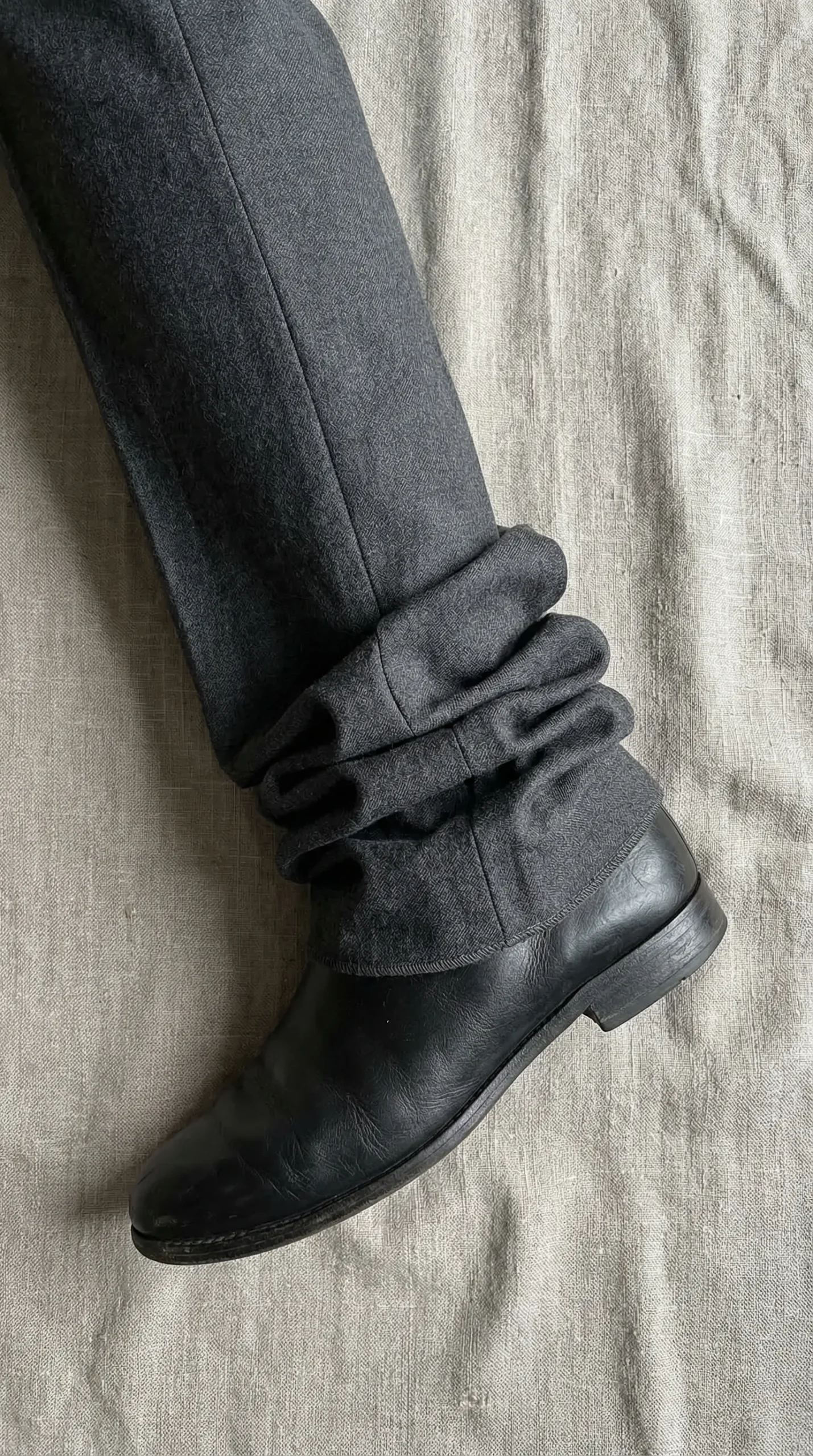 Close-up of trouser hem bunching and pooling around ankle — the chronic wrong hem problem