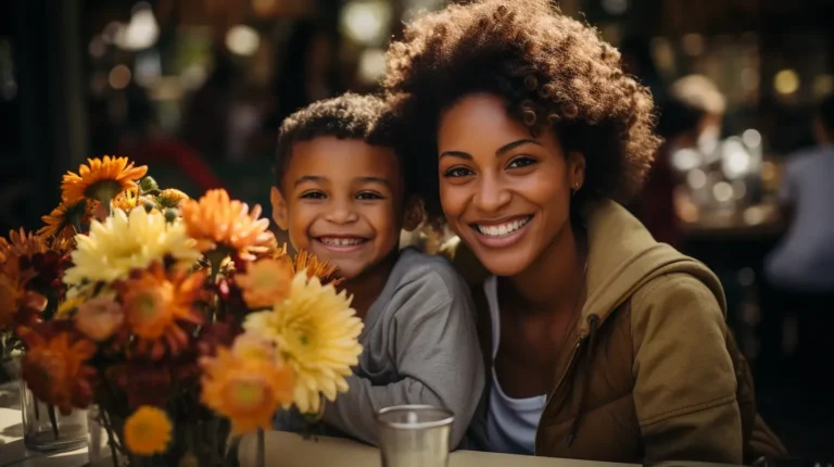 afro-american mother and her son sitting at a table, smiling at the camera - Mother Son Event Ideas